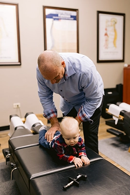 Chiropractor Harrison AR Paul Williams Adjusting Baby